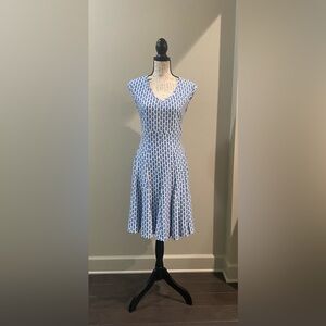 Fitted v-neck dress has a bottom flare. It hits just below the knee.